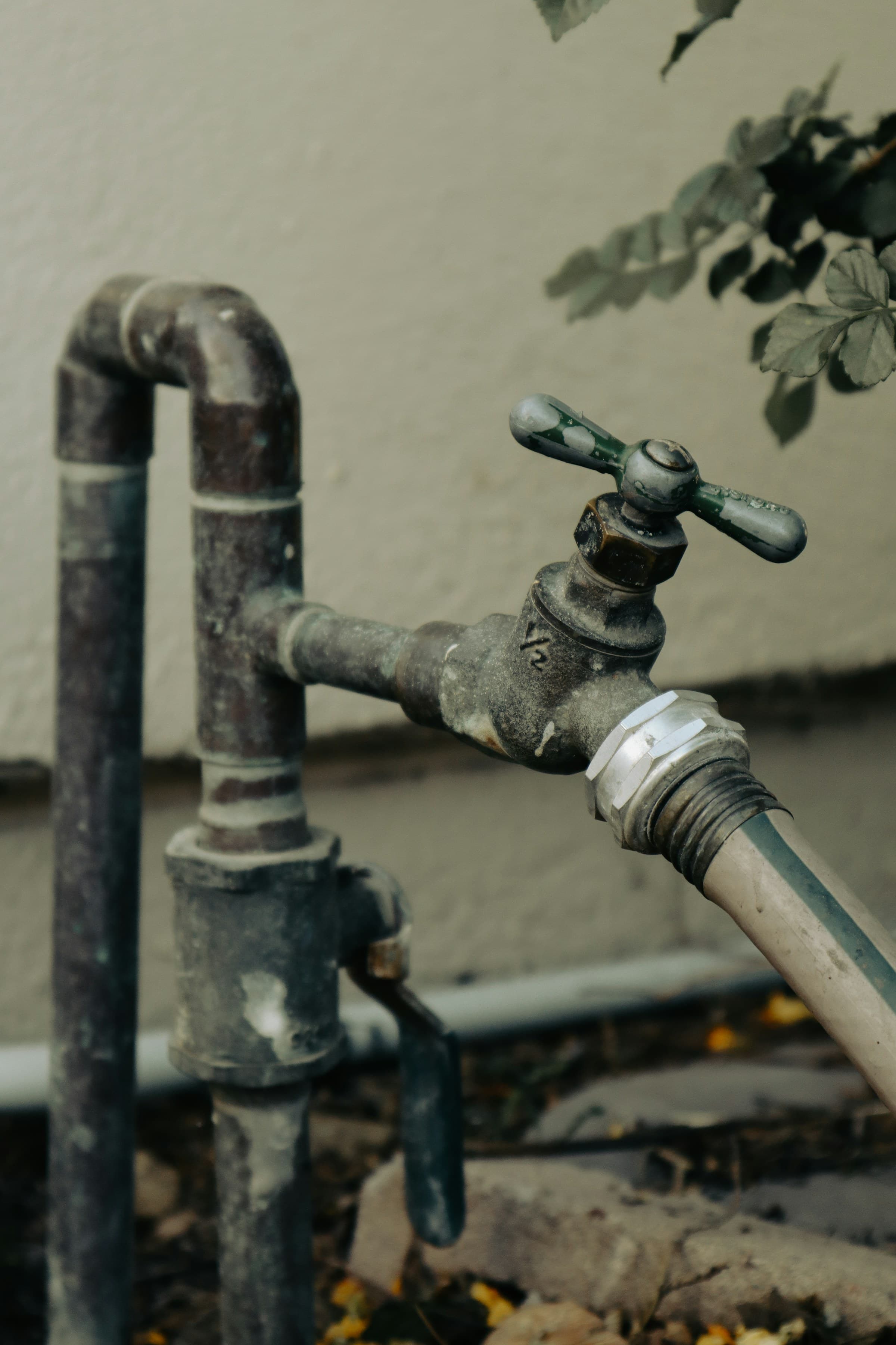 Old outdoor faucet with hose attached