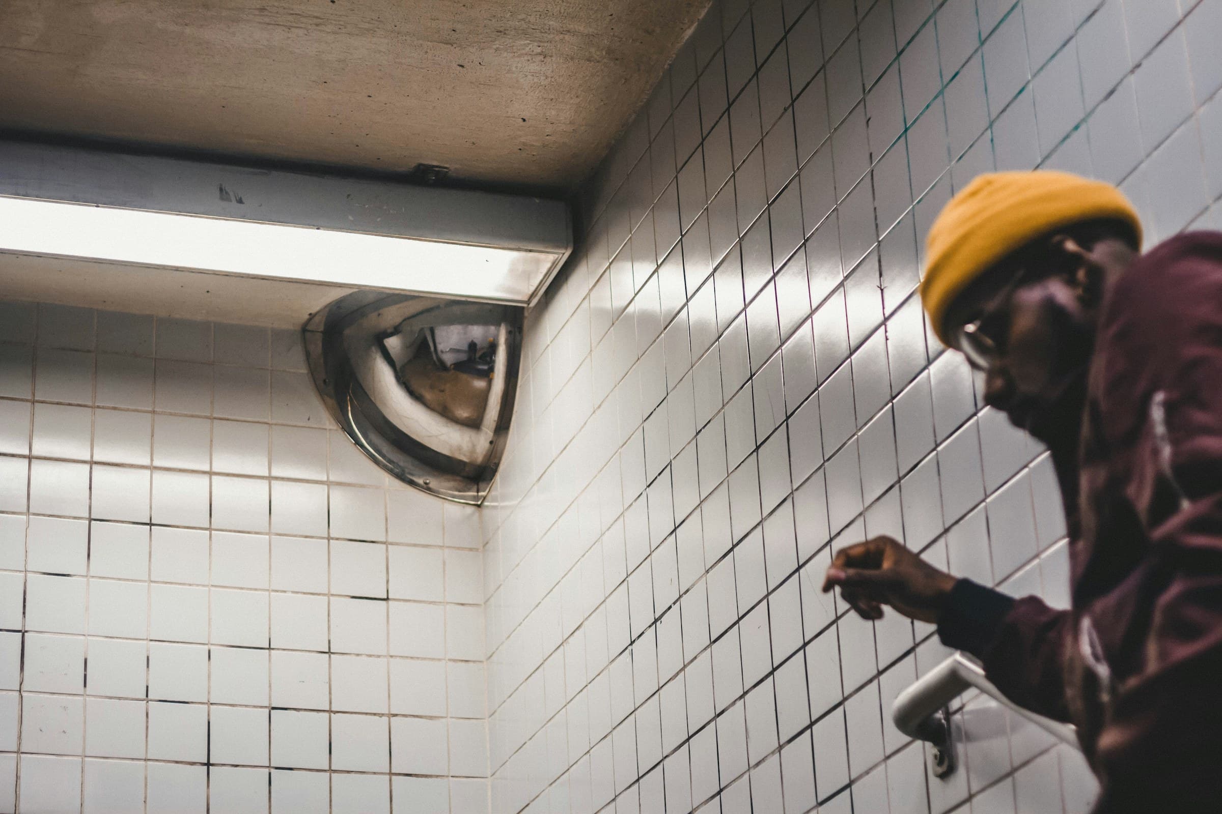 Plumber inspecting a tiled shower wall