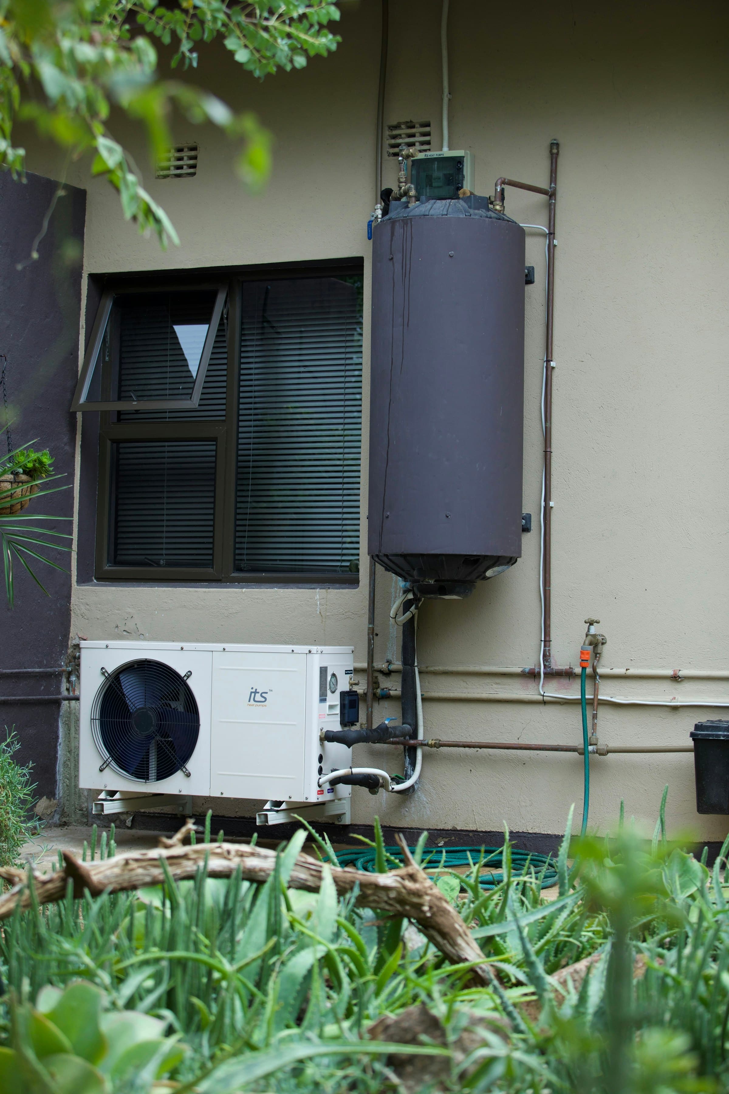 Residential water heater and heat pump on an exterior wall