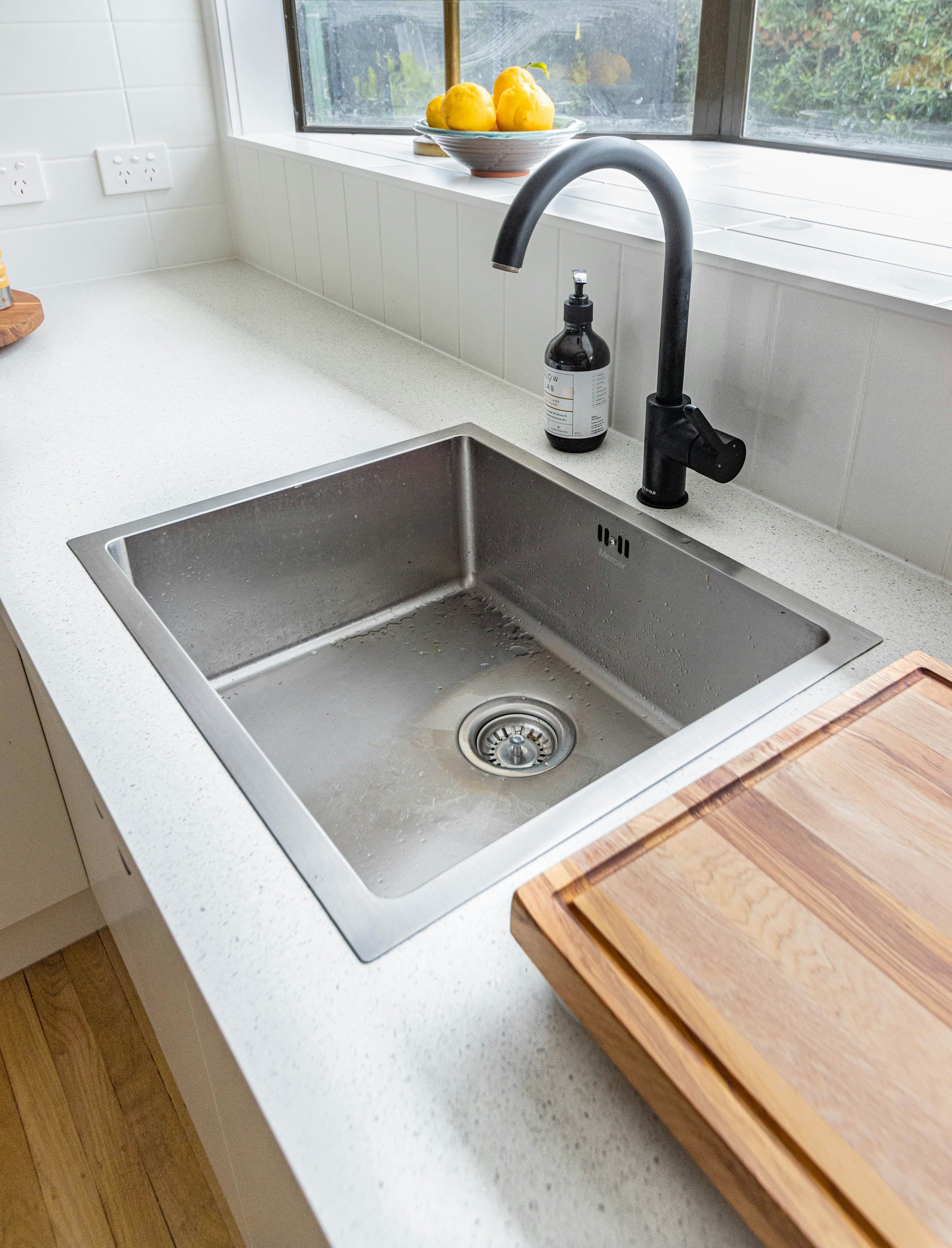 Stainless steel kitchen sink with black faucet