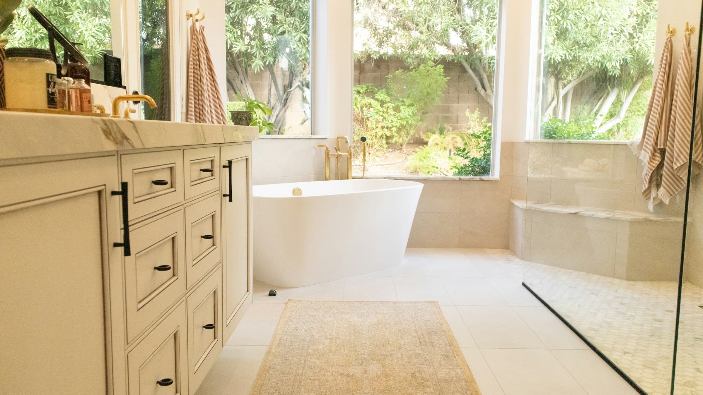 Bright bathroom with freestanding tub and cream vanity