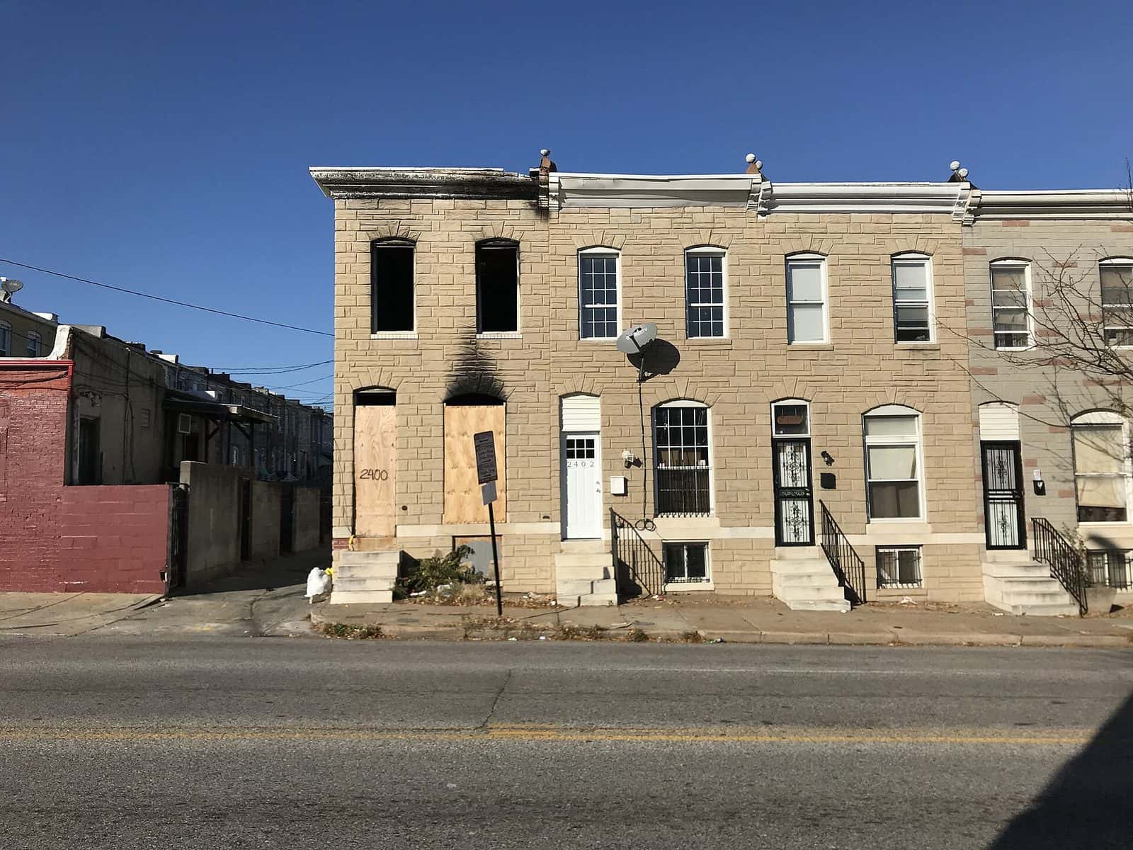 Row house with windows boarded up after a fire