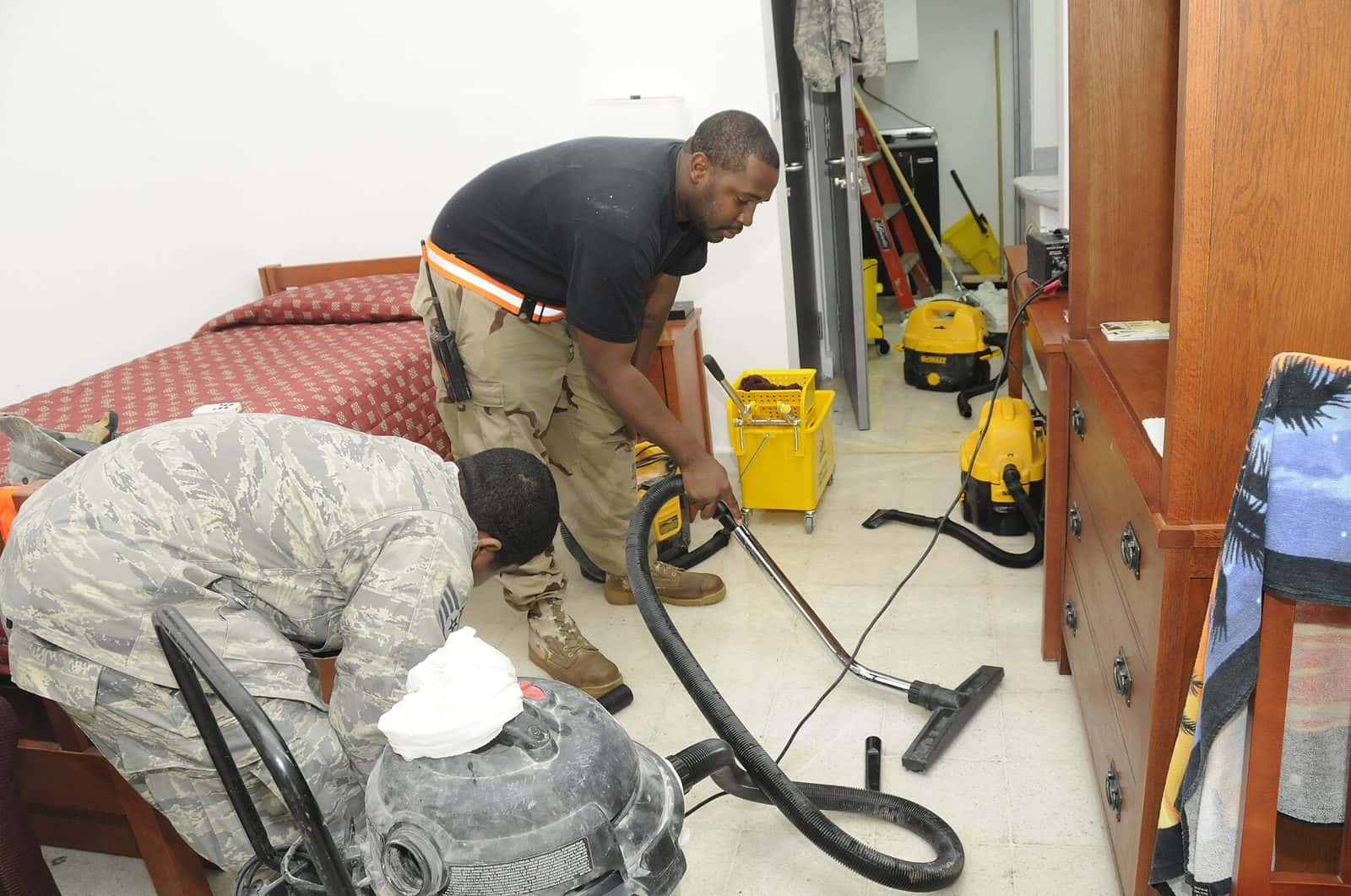 Crew extracting water from a flooded room with wet vacuums